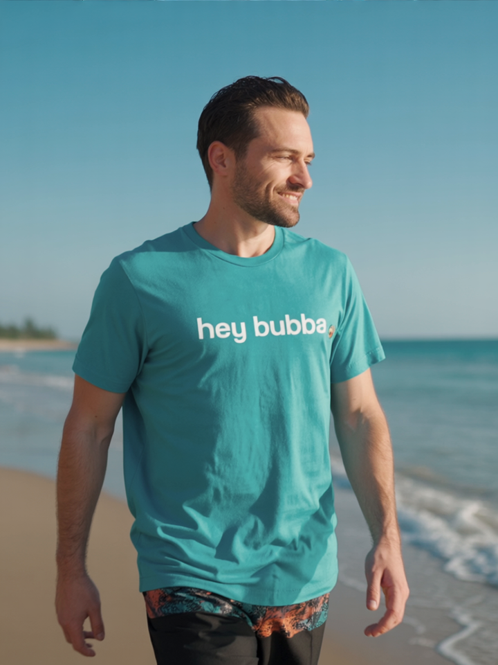 Man wearing a teal 'hey bubba' t-shirt on a beach